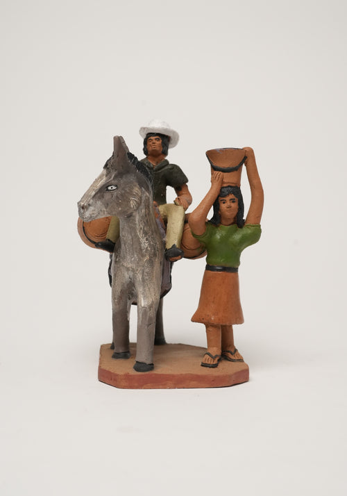 Identidad manabita hombre montando burro y mujer con balde en la cabeza