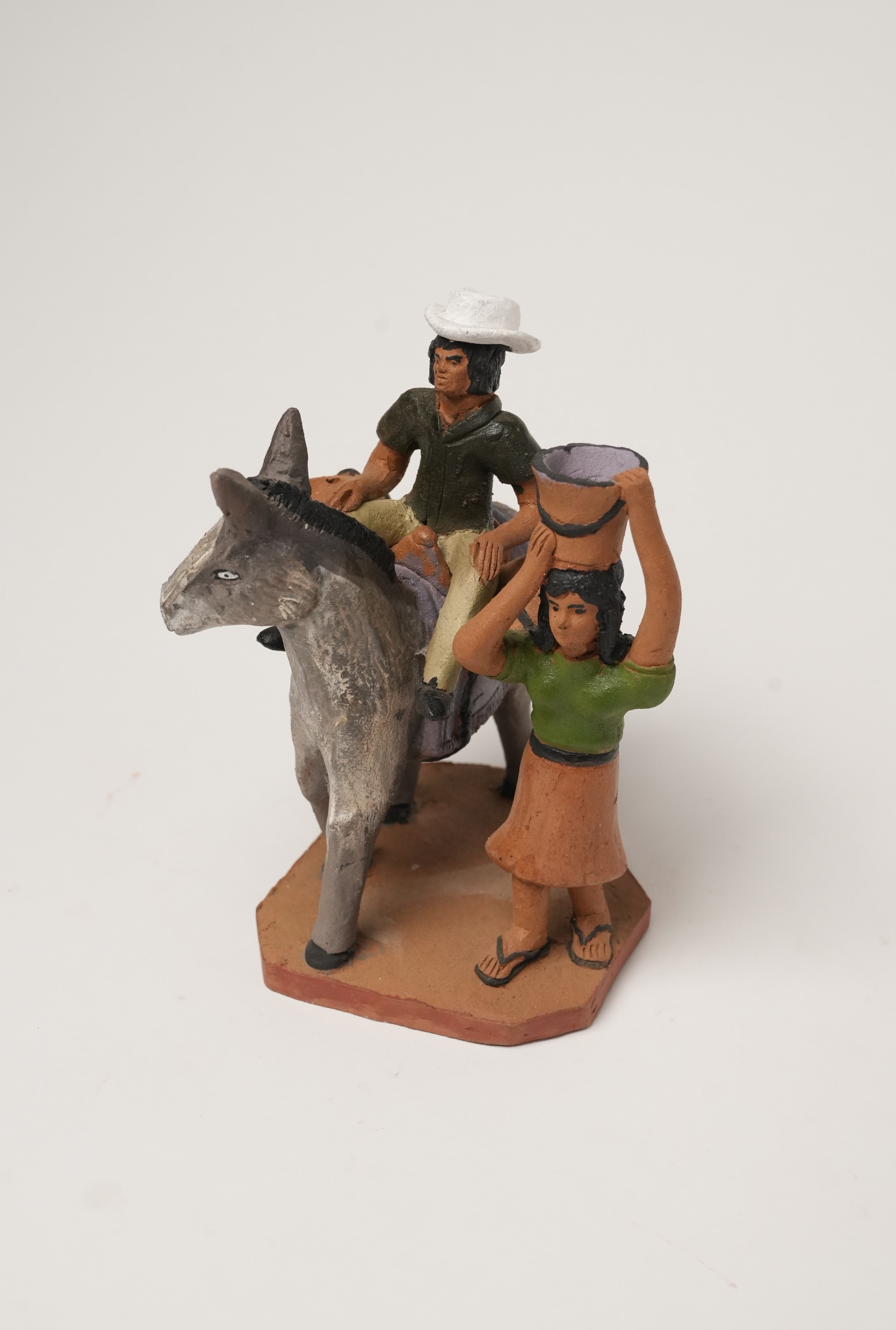 Identidad manabita hombre montando burro y mujer con balde en la cabeza